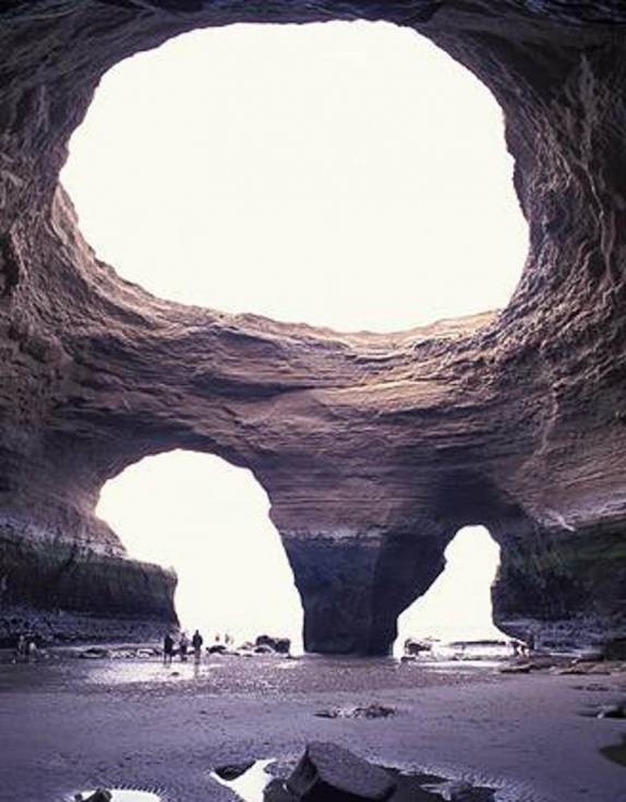 Turistas visitam a caverna La Olla, no Parque Nacional Monte León, no litoral sul da Argentina (foto do site 'The Photographer's')